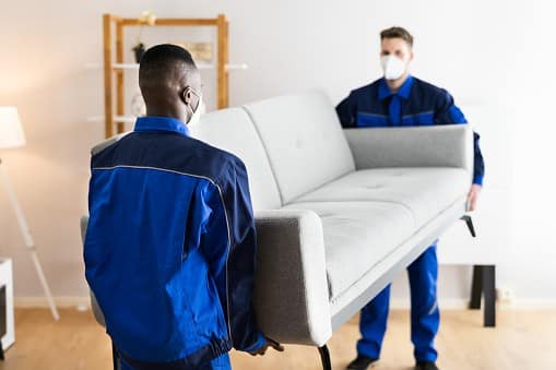 Furniture Movers Relocating House In Covid Face Mask